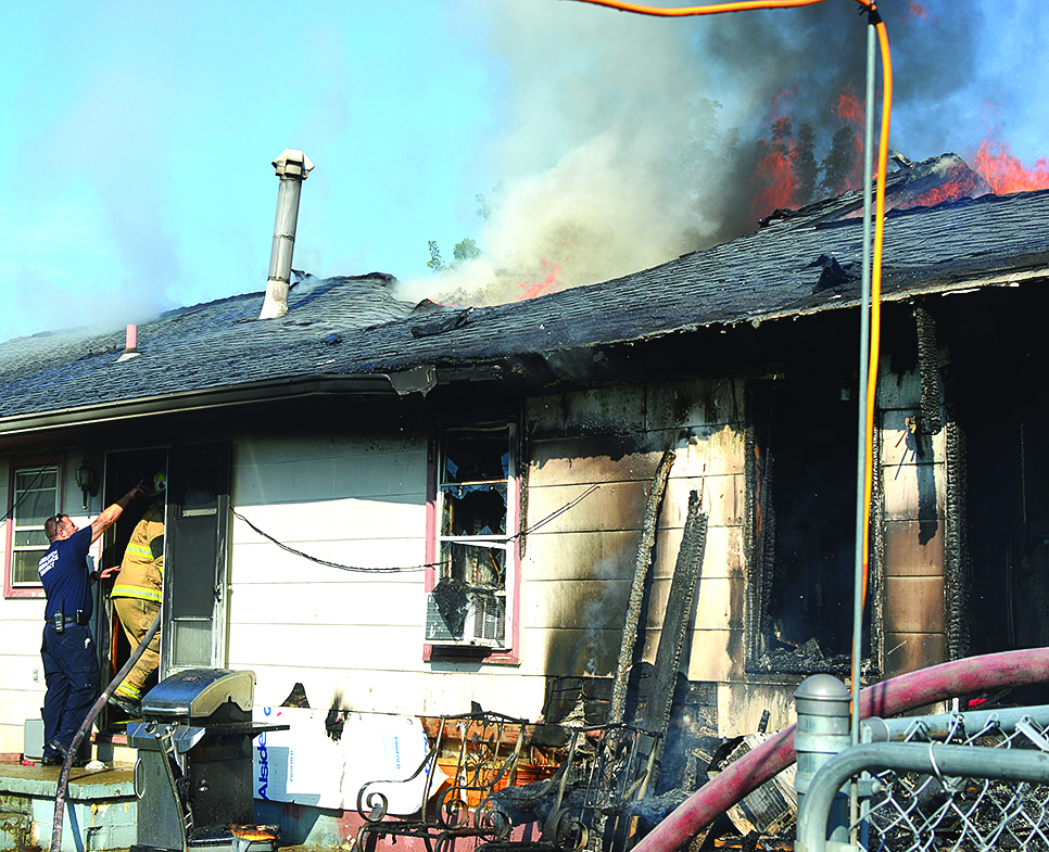 Nathan Gilbert and Ryan Marquardt of Falmouth Fire Department breached the back door to try and get water on the flames 