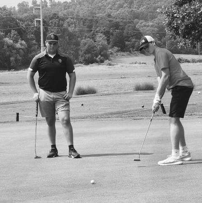 Wildcats senior Abraham Beebe (right) looks to sink a put attempt during the Pendleton County Invitational at Pendleton Hills. Photo courtesy of Amber Beebe.