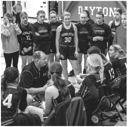Ladycats head coach Patrick Kelsch talks strategy with the team during a timeout. Photo by Pete Wigginton.