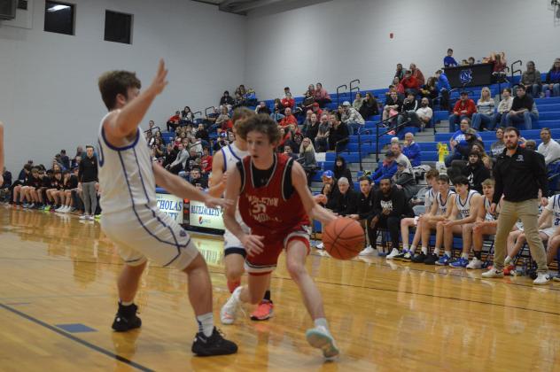 Wildcats junior Aden Merrill maneuvers around the Nicholas Co. defense to score two of his 16 points in the Feb. 2 match up. Photo by Sam McClanahan.
