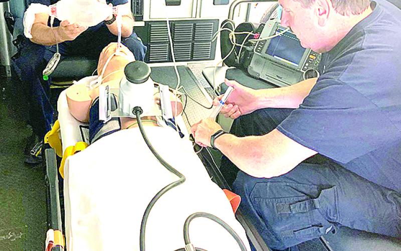 Ken Smith, EMT, and Keith Workman, Paramedic, is working on a practice patient with their new piece of equipment.