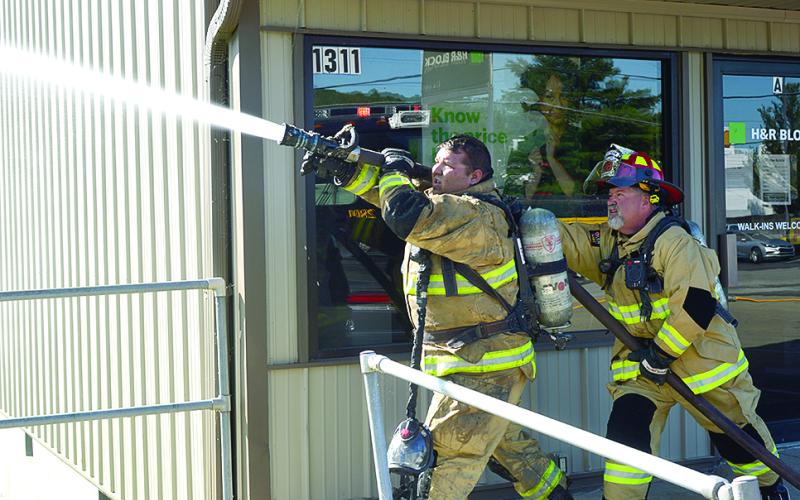 Two Northern Pendleton firefighters handle the hose