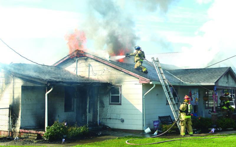 A fireman scaled the roof of the building home to try and get water on the flames