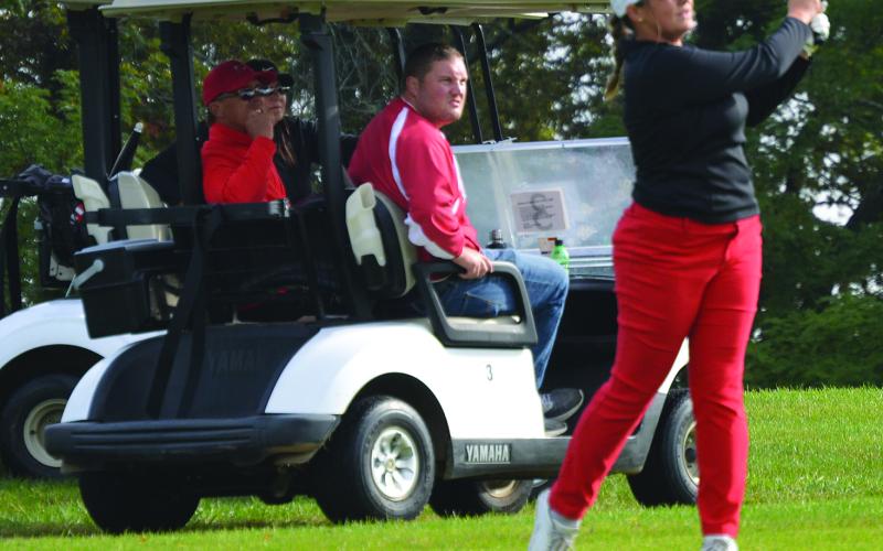 Emilie Bertram with a drive on #11 with Coach Rob Bertram, mom Jodi and AD Jordan Woodruff watching. Photos by Keith Smith
