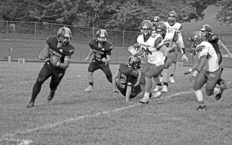 Wildcat Tyler Redden sweeps around the end as Vincent Nocero trails the play against Nicholas County. Photo by Scott Collins