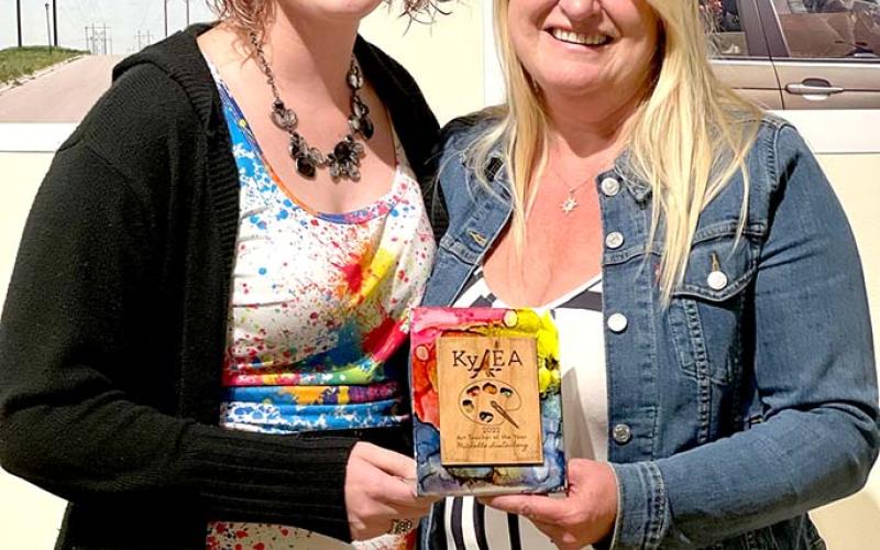 Former student Rachael King Burriss presents Michelle Lustenberg with the Kentucky Art Educator award at this year’s Kentucky Art Education Association’s  conference.