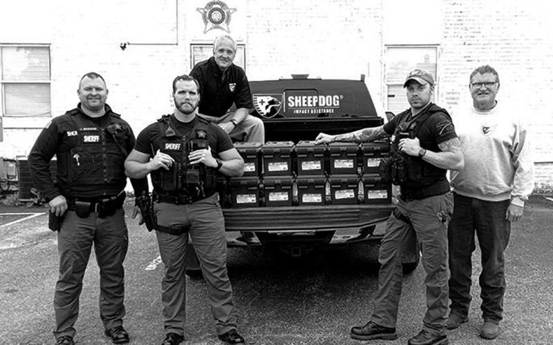 Sheriff Jared Brewer and some of his deputies show off their new medical kits. The kits were delivered by David Jardon of Sheep Dogs Impact Assistance, a group of veterans and first responders who reach out to support in disasters and support each other through Get Off the Couch programming, a volunteer and activity opportunity.  Pictured are, from left to right, Sheriff Jared Brewer, Dep. Nathan Reinhart, Jardon (in truck), Dep. Steve Linville, and Blaine Hagins, another Sheep Dog member.