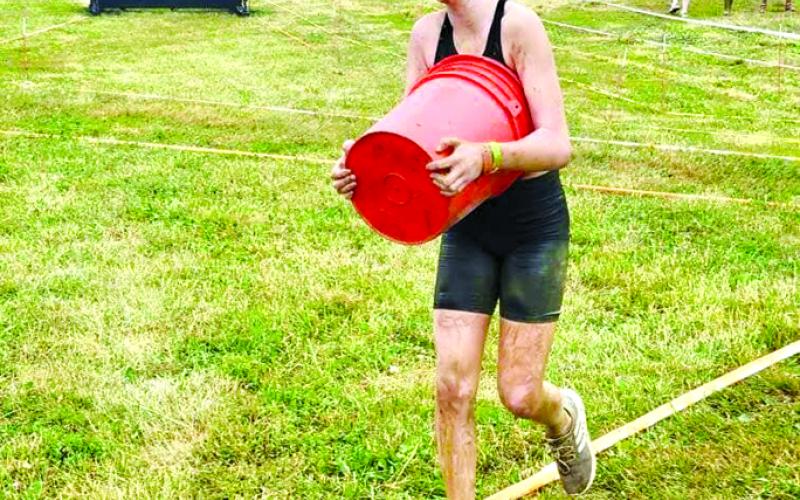Dorothy Beebe lugs a handle-less bucket filled with rocks as one of the obstacles in the Spartan Race.