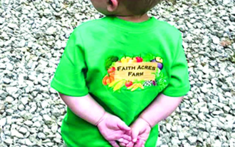 A little guy shows off his love for Faith Acres Farms.
