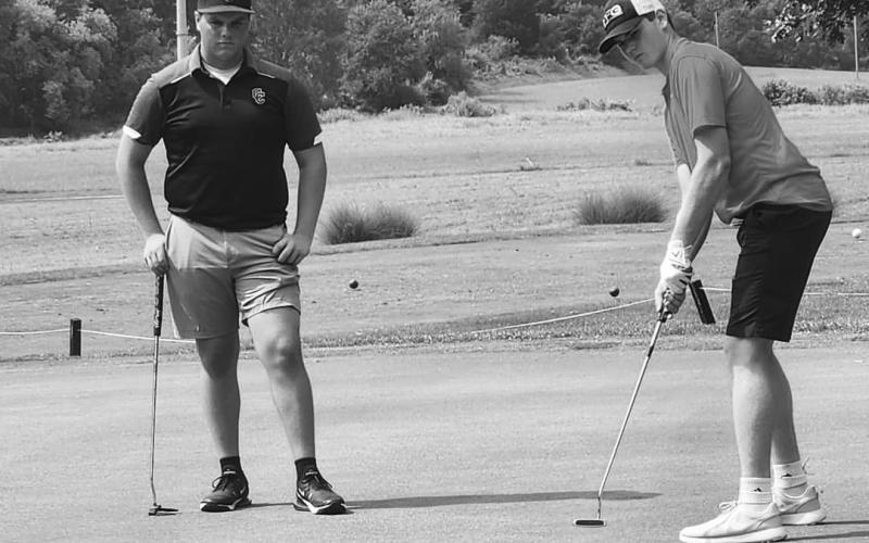 Wildcats senior Abraham Beebe (right) looks to sink a put attempt during the Pendleton County Invitational at Pendleton Hills. Photo courtesy of Amber Beebe.
