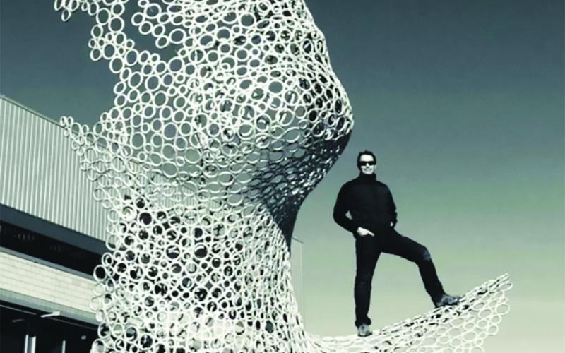 Blumberg poses on his public work sculpture "Convergence" at the Unified State Lab Facility in Salt Lake City, UT
