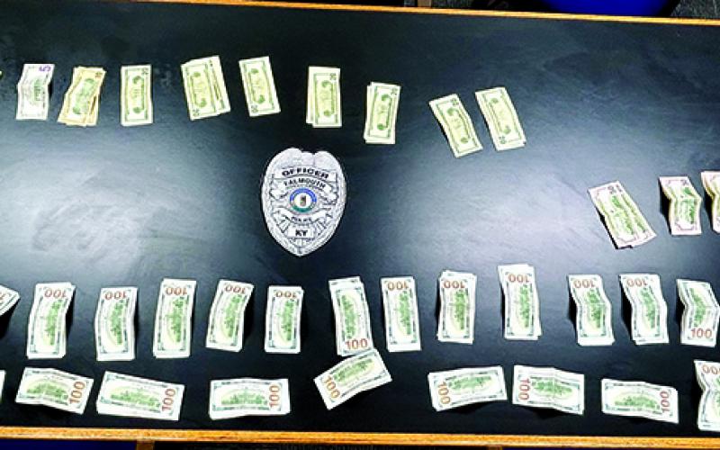 The cash was still being counted at the time this photo was taken. The amount at that time had been confirmed to be $28,000 plus. Small bills were yet to be counted, leading to the officers estimating the take at about $30,000.