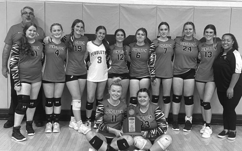 Ladycats pose with their District runner-up trophy. Photo courtesy of Sam McClanahan and Will Jones/10thregion.comy. Bottom Left: Allison Aulick serves up an ace for the Ladycats.