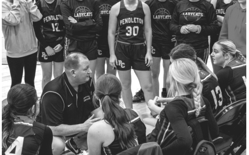 Ladycats head coach Patrick Kelsch talks strategy with the team during a timeout. Photo by Pete Wigginton.