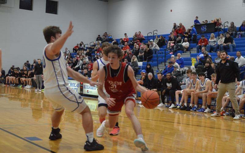 Wildcats junior Aden Merrill maneuvers around the Nicholas Co. defense to score two of his 16 points in the Feb. 2 match up. Photo by Sam McClanahan.