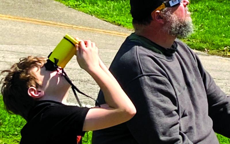 Samuel Pearson, using Sunoculars, and his dad, Joe, of McKinneysburg, watch the solar eclipse from a park in Connersville, Ind., where the eclipse was total. Photo by Hannah Pearson.