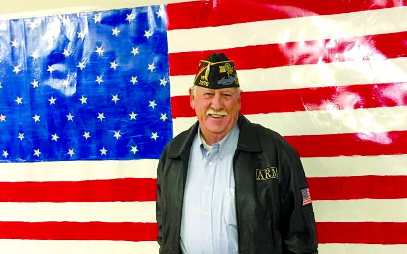 Roy Mains of Falmouth, poses with an American flag.