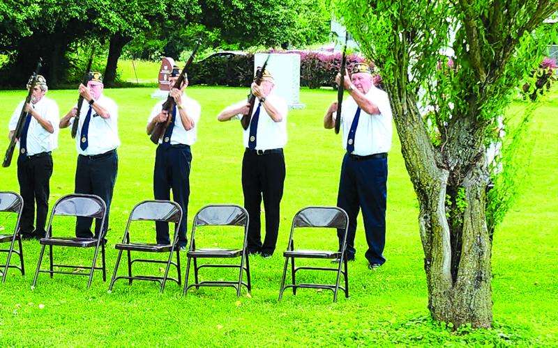 The Hardin Browning American Legion Post 109 Honor Guard fires a 21-gun salute during Memorial Day ceremonies. From left at Tom Rector, Mark Fields, Steve Bowman, Mark Zaffuto, David Emerick, Mike Helmer and Rick Herzog (behind tree), with Gary Barnard making the calls.