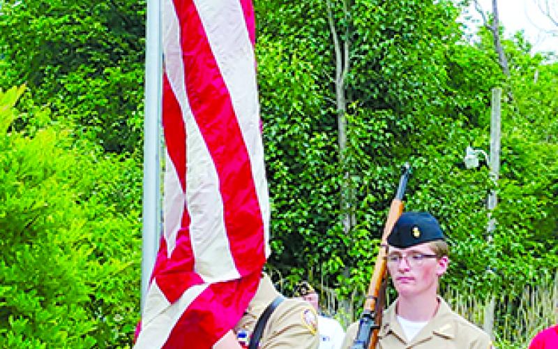 NJROTC cadets Micah Seksay, holding the flag, and Tanner Morris retire the colors after the singing of the national anthem.