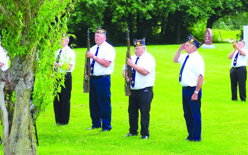 Herman Schack, right, plays taps. Standing at attention are, from left, David Emerick (partially obstructed by tree), Mike Helmer, Reick Hertzog and Gary Barnard.