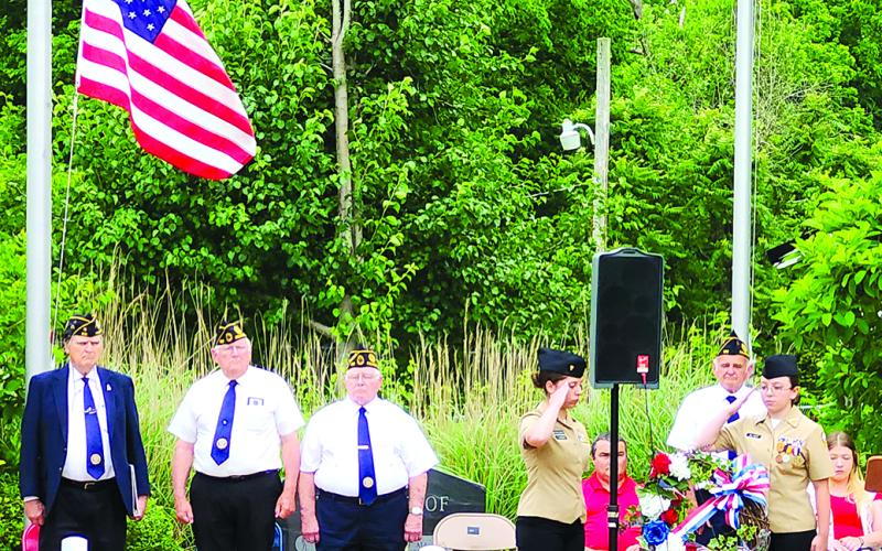 Pendleton County High School Navy Junior Reserve Officers Training Corps cadets Catalina Furman, left, and Georgia Oliver salute the wreath placed to honor military personnel who died while serving in the U.S. Armed Forces.  American Legion members, standing from left, are Donald Wells, Johnnie Parsons, Tom Rector and Gary Barnard.
