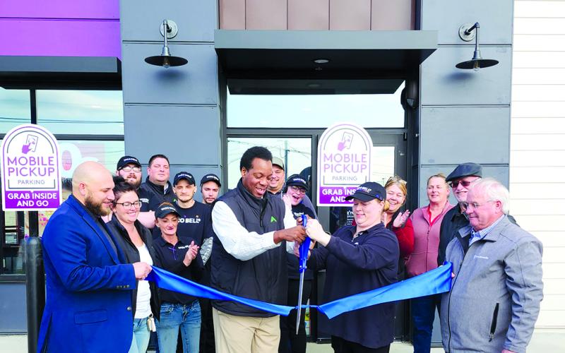 In front with the ribbon are Geison Cunha, vice president of operations, left; Charles Hanes, district manager; Craddock; and Gary Hicks, president of the Pendleton County Chamber of Commerce. Photo by Burton Cole.