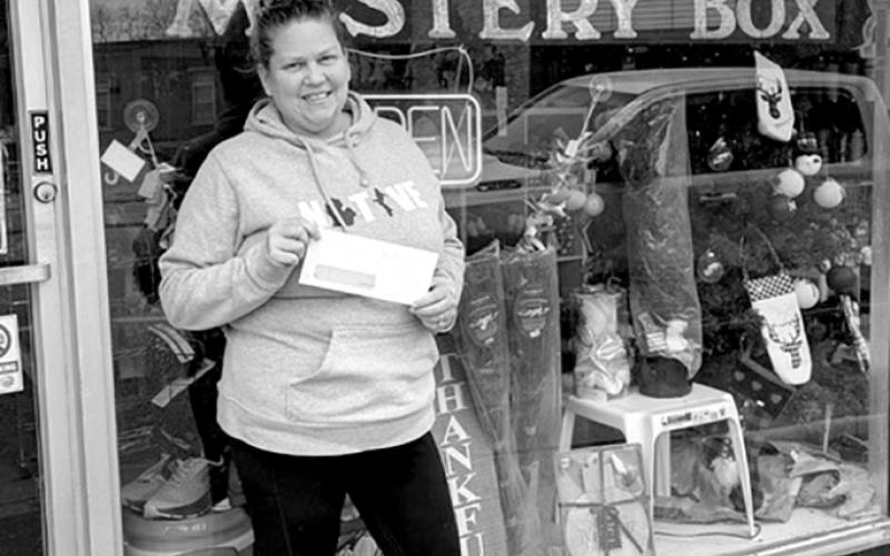 The Mystery Box, 125 W. Shelby St., Falmouth, said it plans to use its grant to purchase shelving units and paint. Owner Jennifer Larabee said she opened the store of “fun stuff at a discounted price” two years ago to become more self-reliant. Here, Larabee holds her Duke Energy Foundation support check.