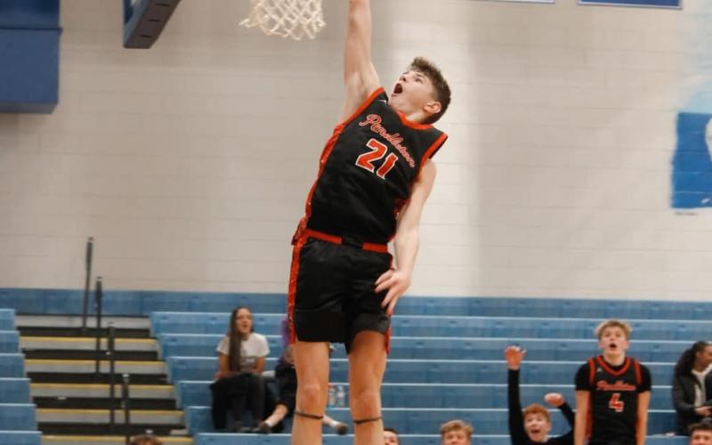 Wildcats sophomore Kamden O'Hara skies for his first career in-game dunk versus Bracken County as his teammates celebrate from the bench. Photo by Layne Nelson.