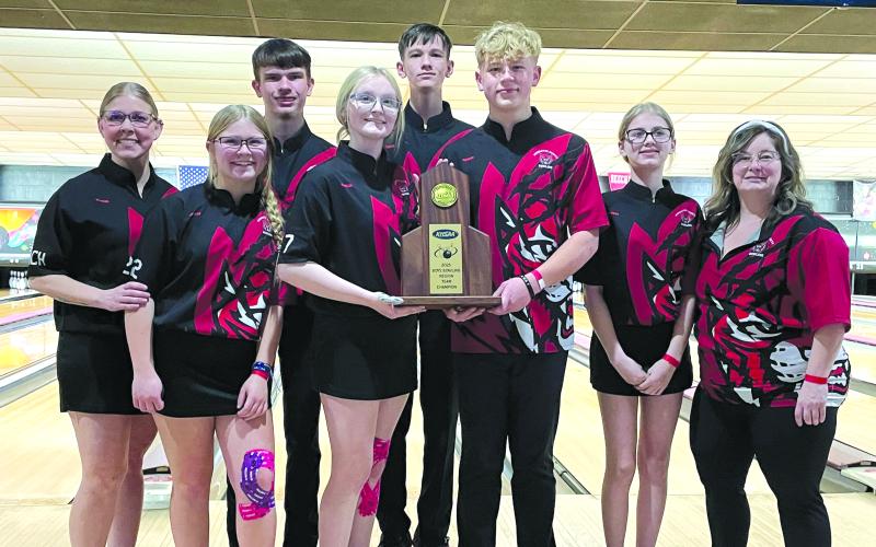 With the scoreboard in the background displaying the score of the final game, the Pendleton County High School poses with the trophy after winning the Region 5 Boys Team Competition for the fifth consecutive year. In the back are Braden Brann and Adam Straus. In the front from left are head coach Amber Hutchison Brewer, Kree Brewer, Maddie Marshall, Kyan Brewer, Emma-Lee Chappell and coach Jennifer Thomas. Photo by Rhonda Hutchison.