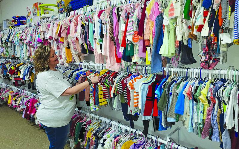 Shannon Wells, the new director of the New Hope Pregnancy Center in Falmouth, sorts through hangars of clothes in the center’s closet, where expectant parents can pick out supplies. Photo by Burton Cole.