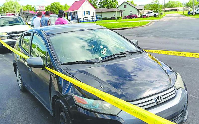 Bullet holes are seen in the windshield and hood of this sedan after a shootout Saturday between the occupants of two vehicles. Ethan Groneck, 18, of Alexandria, is in custody, and Adam Duncan, 20, originally of Pendleton County remains at large after the gunplay that followed an argument, police said. No one was injured. Photo by Sam McClanahan.