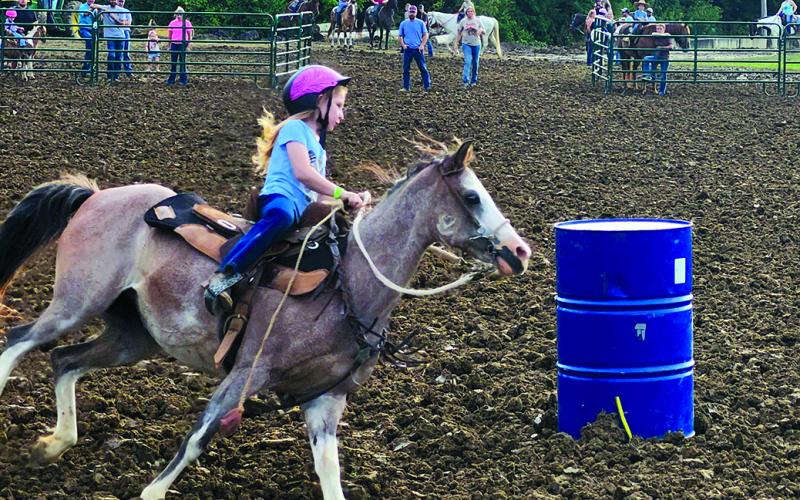 Finley Thomas, 6, of Falmouth scores an excellent run in the peewee class of barrel racing Thursday night at the fair. Photo by Burton Cole.