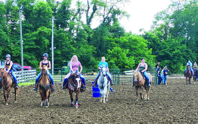 Riders warm up their horses before the start of the horse show Thursday night. Photo by Burton Cole.