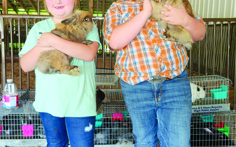 Anna Carson, 6, of Butler, left, holds Cinnamon, a lionhead rabbit, while her sister, Paisley, 9, nuzzles Sunflower, who is Cinnamon’s mom. Along with rabbits, Paisley also shows goats this year and hopes to show steer at the fair in coming years.