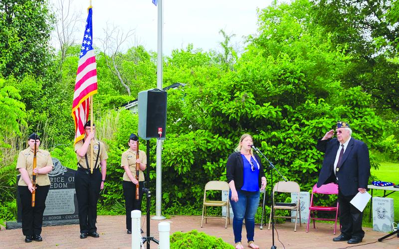 Callie Daugherty sings “The Star-Spangled Banner” during the Memorial Day ceremony May 25 the Hardin Browning American Legion Post 109 in Falmouth. Colors are presented by Pendleton County High School Navy Junior Reserve Officer Training Corps cadets Lona Albos, left, Tanner Morris and Georgia Oliver. At right is Post Commander James Sharp.
