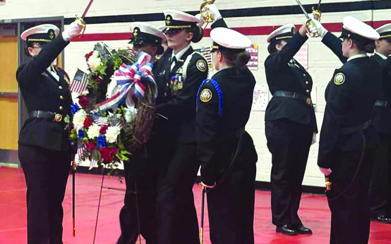Pendleton County High School’s Navy Junior Reserve Officers Training Corps perform a wreath-laying ceremony, paying tribute to veterans past and present, during a dinner the school district put on on Veterans Day last week for the servicemen and women of the community.