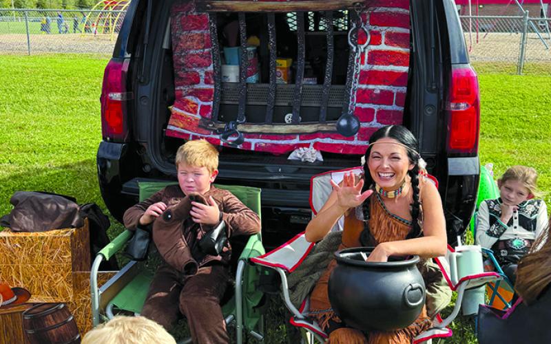 Pendleton County Sheriff Jared Brewer’s wife, Amber, and children Biden and Brynlee pass out candy with their car decorated as a jail at Northern Elementary School PTO’s Trunk or Treat event. Photo by Nila Harris.