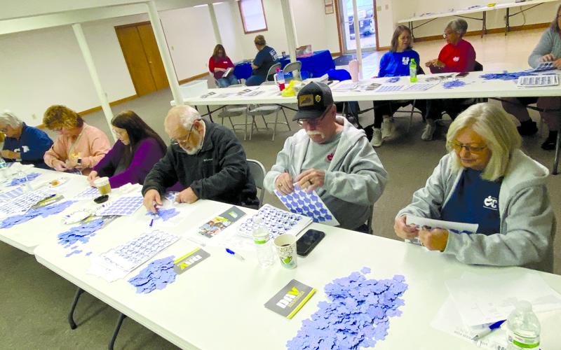 Pendleton County Retired and Senior Volunteer Program members worked a service project Monday morning with Disabled American Veterans, affixing 3,000 forget-me-knots to thank-you cards to be mailed to veterans. Today, Nov. 11, is Veterans Day,  a day to honor veterans of the United States Armed Forces. Photo by Lisa Wiggins.