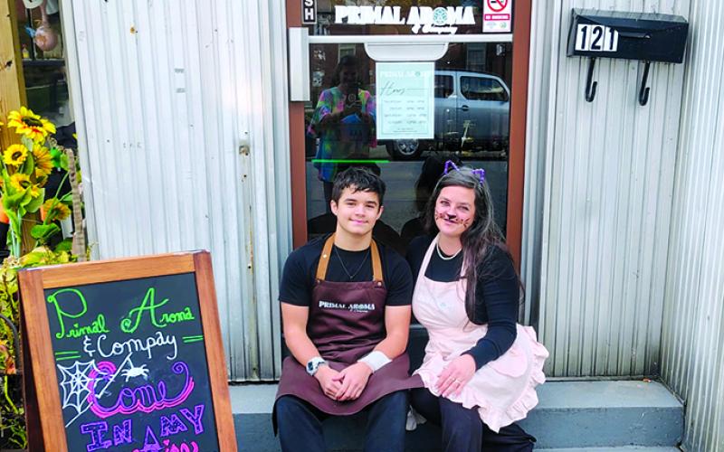 Ashley Cassidy, right, sits beside her son, Wyatt, in front of Primal Aroma and Co., 121 W. Shelby St., Falmouth. The store carries products made from natural ingredients including candles and cosmetics. Photo courtesy of Ashley Cassidy.
