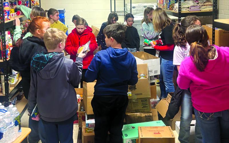 Students from Northern and Southern elementary schools stock the shelves at FRYSC.
