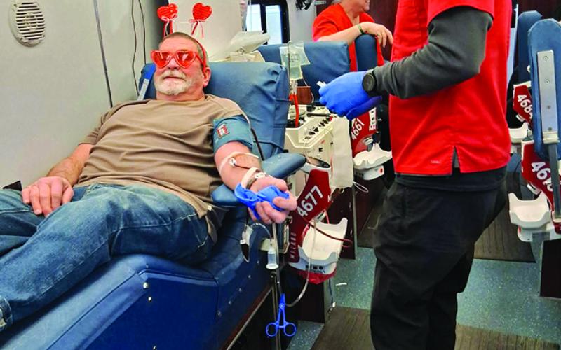 Jeff, sitting, aptly showed up decked out in his Valentine’s Day headwear. He did a “double blood donation,” a process that uses a machine to separate the red cells, collecting them while returning the other components and a saline solution to the donor.