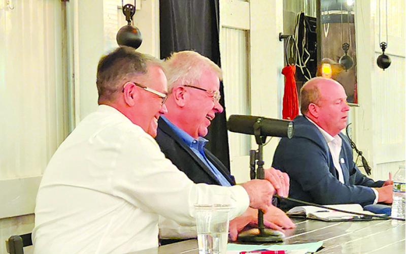 James Poynter and Anthony Strong enjoy a chuckle as Rick Mineer makes a crack during the debate.