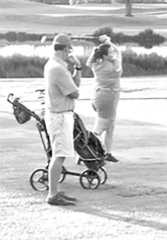 Coach Rob Bertram watches Stormy Ward tee off