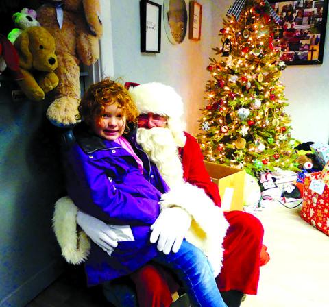 Santa listens to a young lady give her wish list as dozens wait for the opportunity. Gifts were piled high in the area, and Kelly Mosley said enough came that she had to make a run to Santa’s workshop to get more.