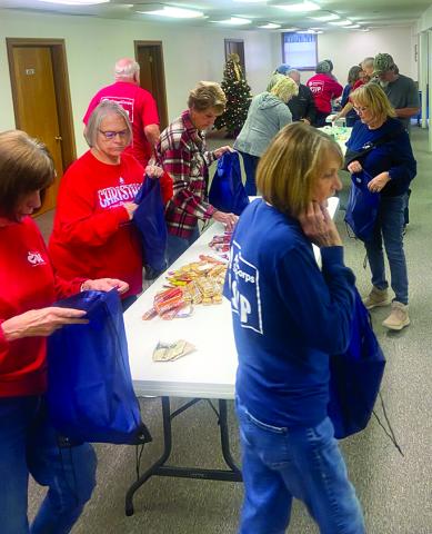 Pendleton County RSVP volunteers stuff canvas bags with snacks and warm clothing to be distributed to the county’s homeless population. Photo courtesy of RSVP.