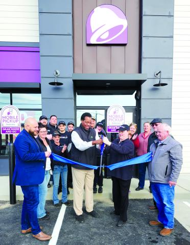 In front with the ribbon are Geison Cunha, vice president of operations, left; Charles Hanes, district manager; Craddock; and Gary Hicks, president of the Pendleton County Chamber of Commerce. Photo by Burton Cole.