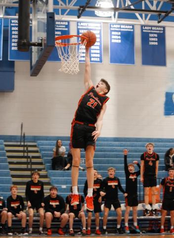 Wildcats sophomore Kamden O'Hara skies for his first career in-game dunk versus Bracken County as his teammates celebrate from the bench. Photo by Layne Nelson.
