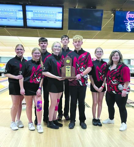 With the scoreboard in the background displaying the score of the final game, the Pendleton County High School poses with the trophy after winning the Region 5 Boys Team Competition for the fifth consecutive year. In the back are Braden Brann and Adam Straus. In the front from left are head coach Amber Hutchison Brewer, Kree Brewer, Maddie Marshall, Kyan Brewer, Emma-Lee Chappell and coach Jennifer Thomas. Photo by Rhonda Hutchison.