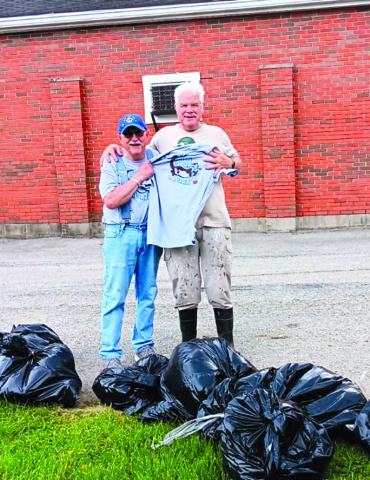 Mac McElfresh, left, and Ron Mouser, president of Butler Lions, display a few of the bags of trash picked up from roadways on April 19. Seven volunteers collected 23 bags of trash and debris. Photo courtesy of Butler Lions.
