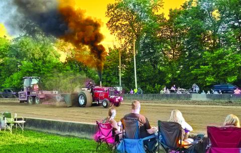 revved-up tractor kicks dirt during the Battle of the Bluegrass Truck and Tractor Pull Friday night during the 2025 edition of the Pendleton County Youth Fair. Photo by Jenny Smith.